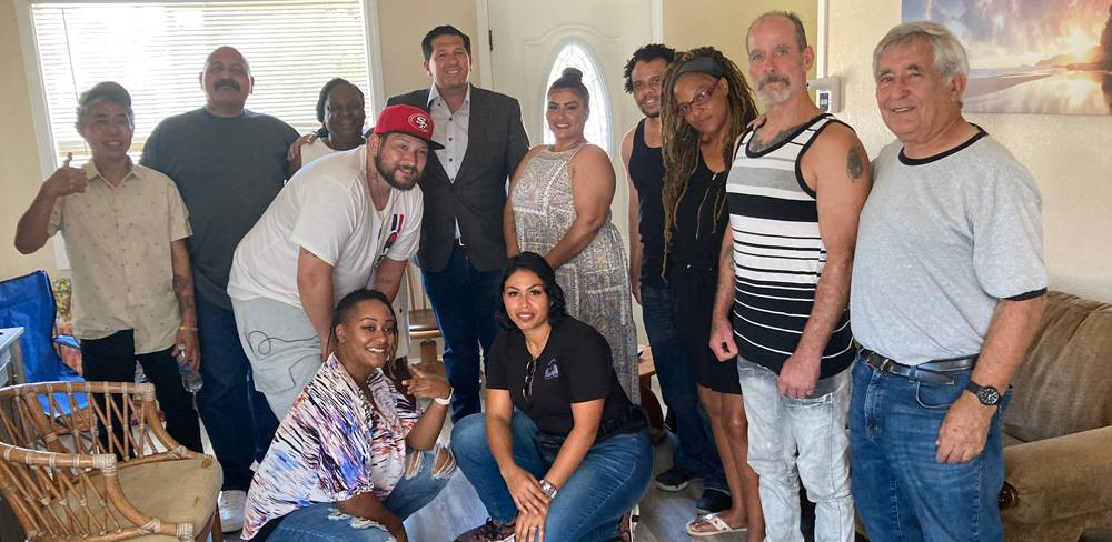 Group of people in living room of Retraining the Village Residential Recovery Residence in East Palo Alto, California